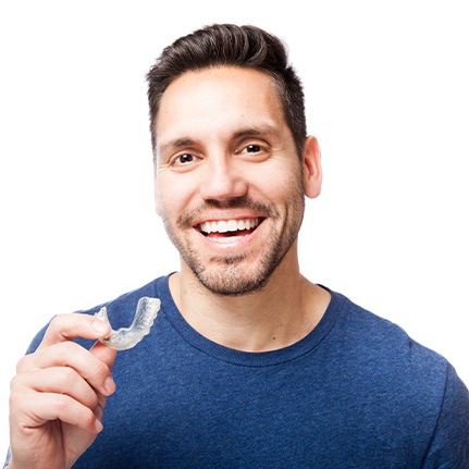 man smiling with oral appliance in hand