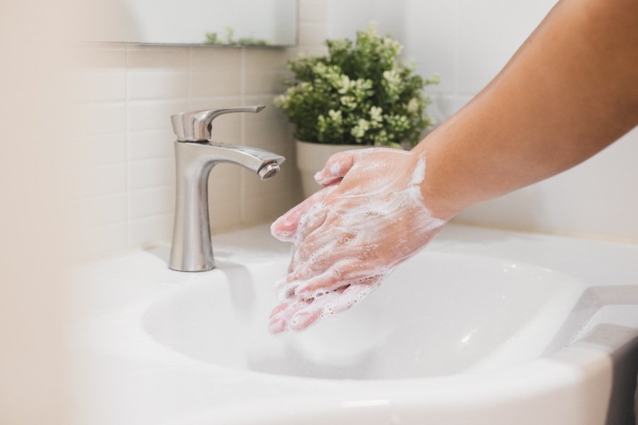 Closeup of a person washing their hands with soap and water