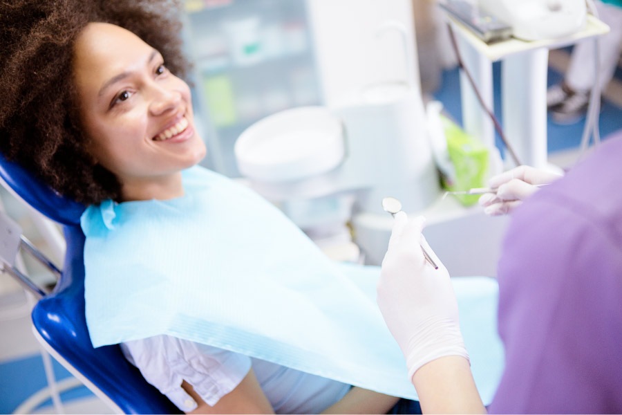 Curly-haired woman smiles at the dentist in Fort Smith, AR