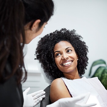 smiling woman talking with her dentist