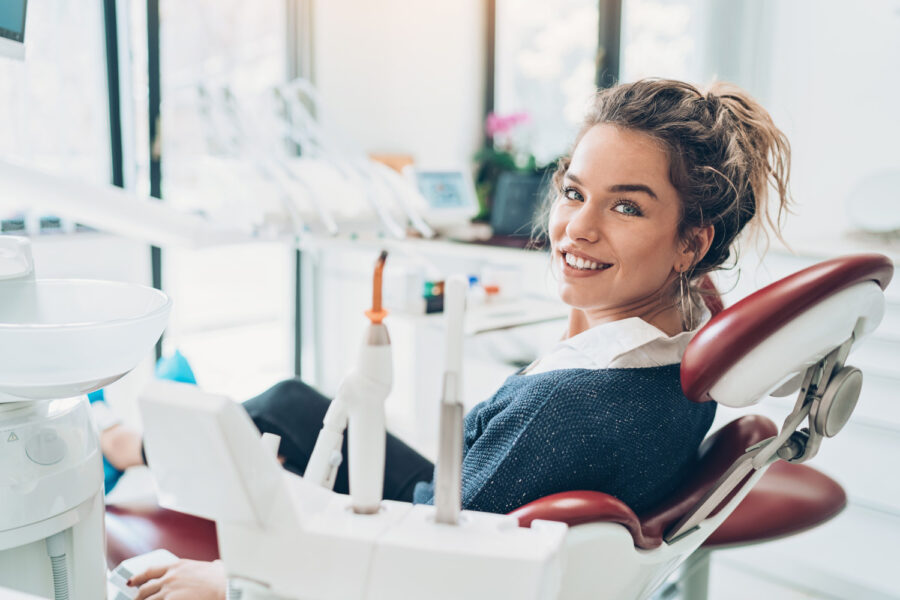 Brunette woman smiles in a dental chair before root canal treatment in Fort Smith, AR