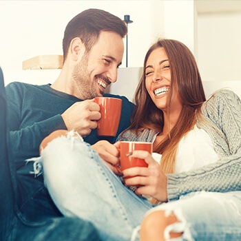 man and woman laughing and having coffee