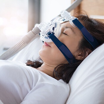 sleeping woman wearing a CPAP machine