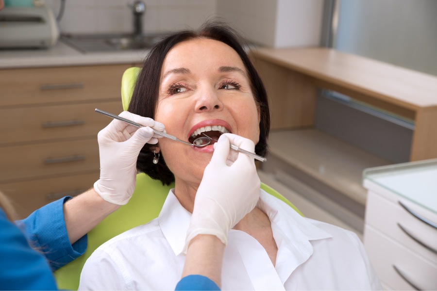 Brunette woman in the dental chair receiving a cleaning and checkup at her dentist in Fort Smith, AR