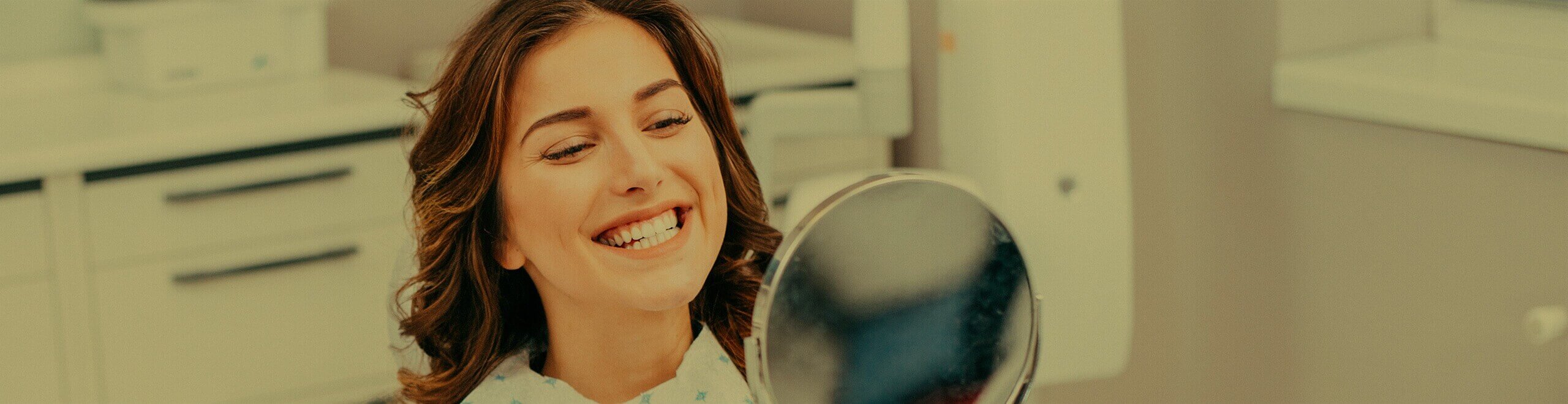 woman examining her white smile in a mirror