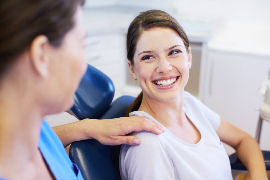 Brunette woman smiles before her routine cleaning and checkup at the dentist in Fort Smith, AR