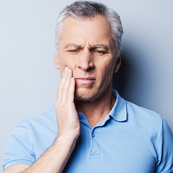 man holding his jaw in pain