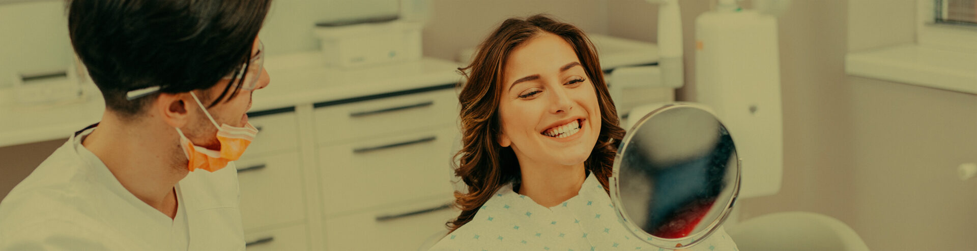 woman examining her smile in a mirror