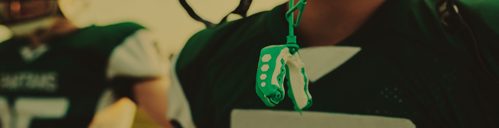 athletic mouthguard hanging from a football player's helmet